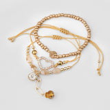 Set de pulseras doradas con dijes y brillos